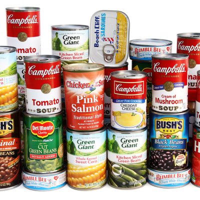 "West Palm Beach, USA - September 15, 2012:  A studio shot of a large assortment of canned foods piled  two layers high and deep. Brands include Campbell's, Bush's, Green Giant, Del Monte, Bumble Bee, Chicken of the Sea and Hunts. Foods include baked beans, black beans, green beans, tomato sauce, corn, several varieties of soup, albacore, salmon, and sardines."